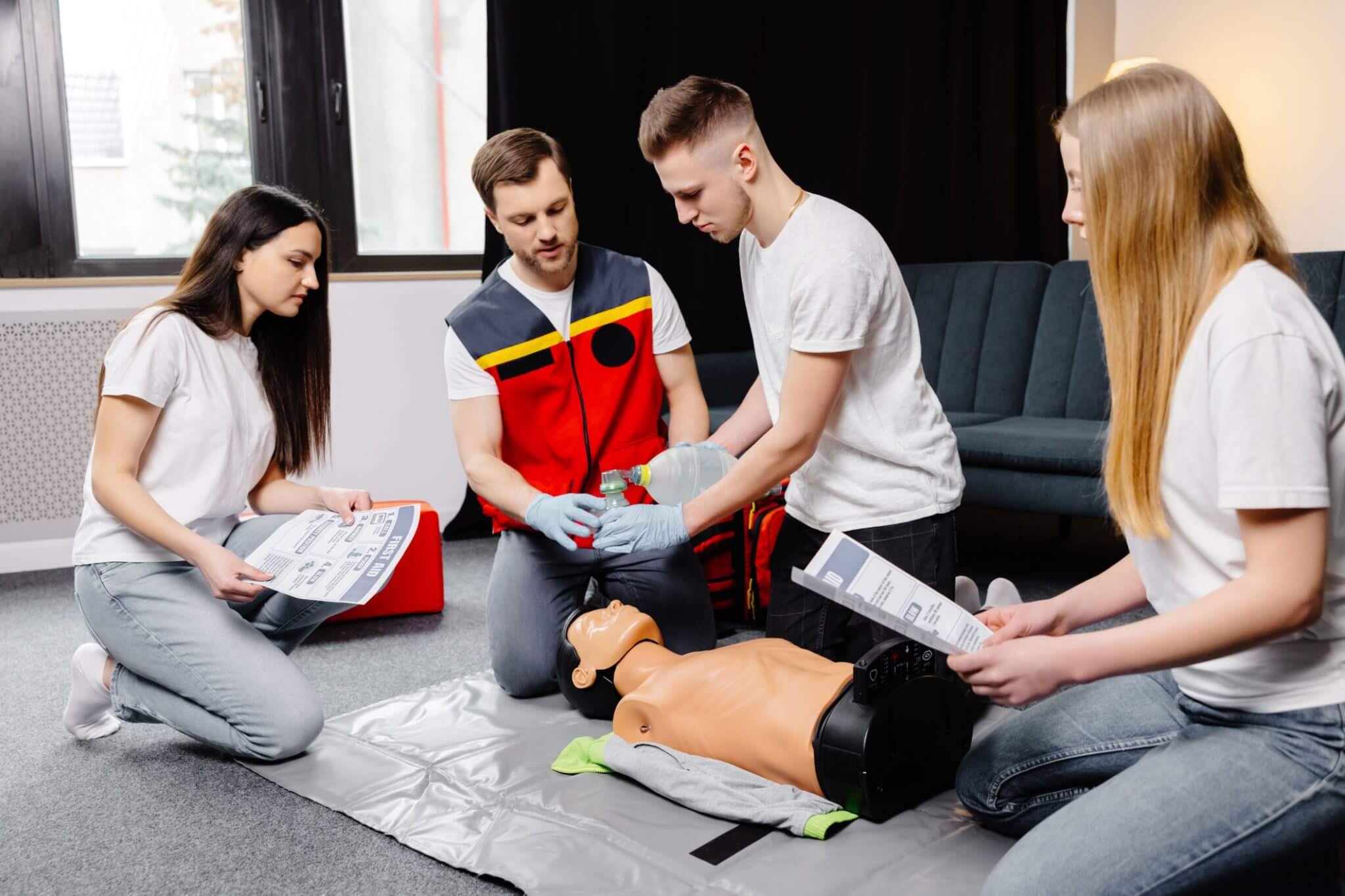 Group learning CPR on a mannequin in a training session.