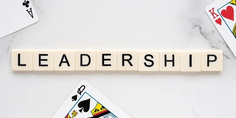 Leadership" spelled with tiles, surrounded by cards.