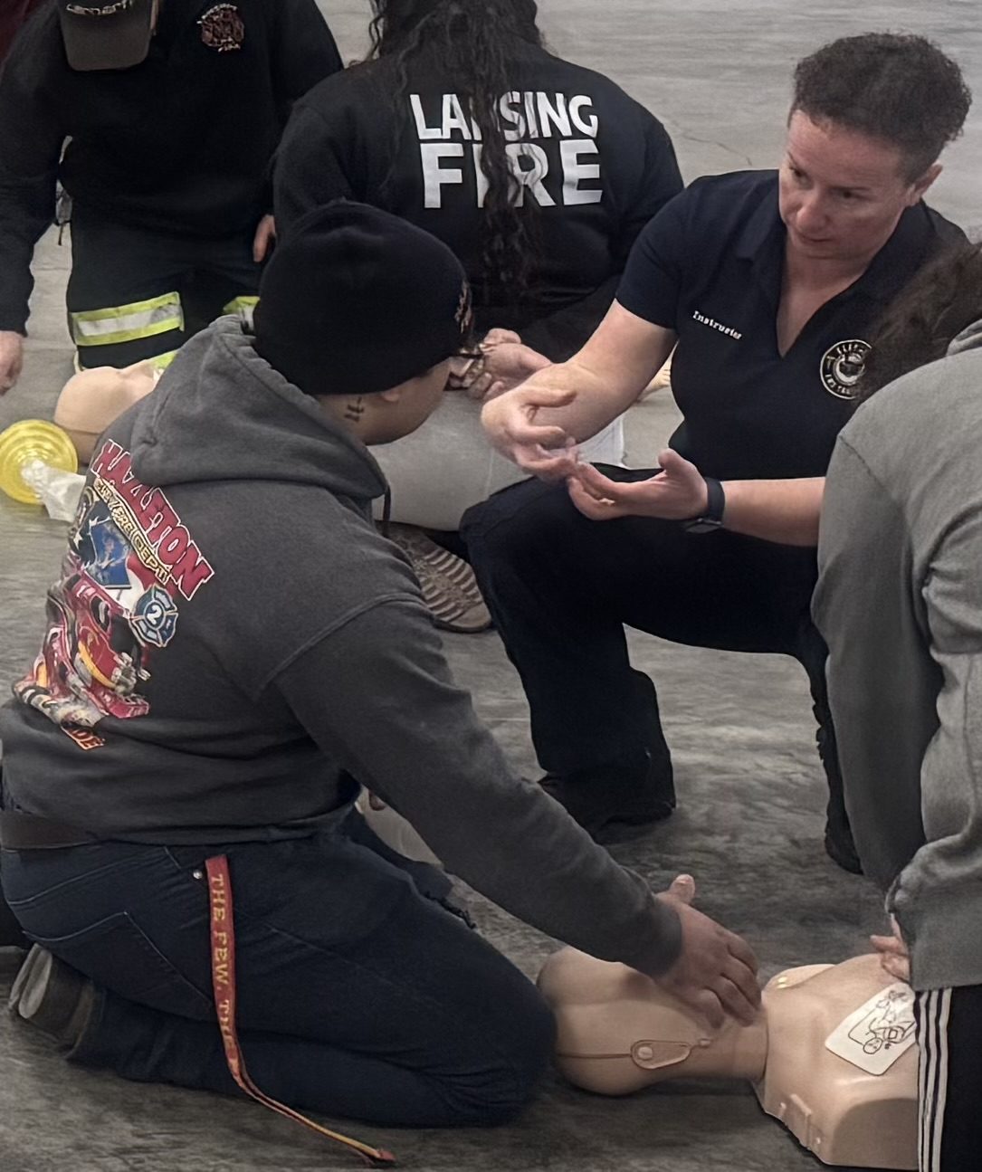 Two people practicing CPR on a training mannequin.